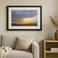 Framed artwork above a sofa with a vase on a side table in a living room setting.