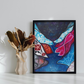 Framed abstract artwork on a white wall with a vase of dried flowers.